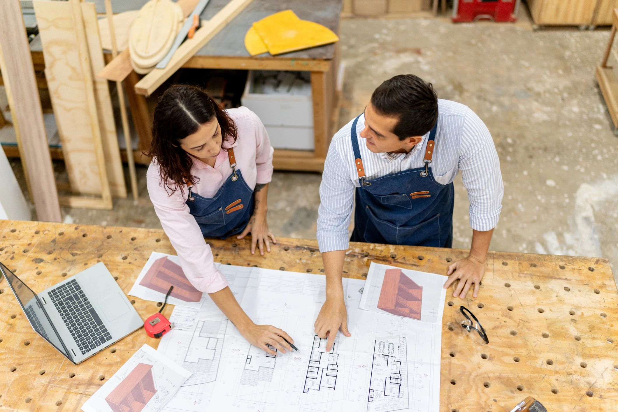 Tradespeople discussing plans in a workshop