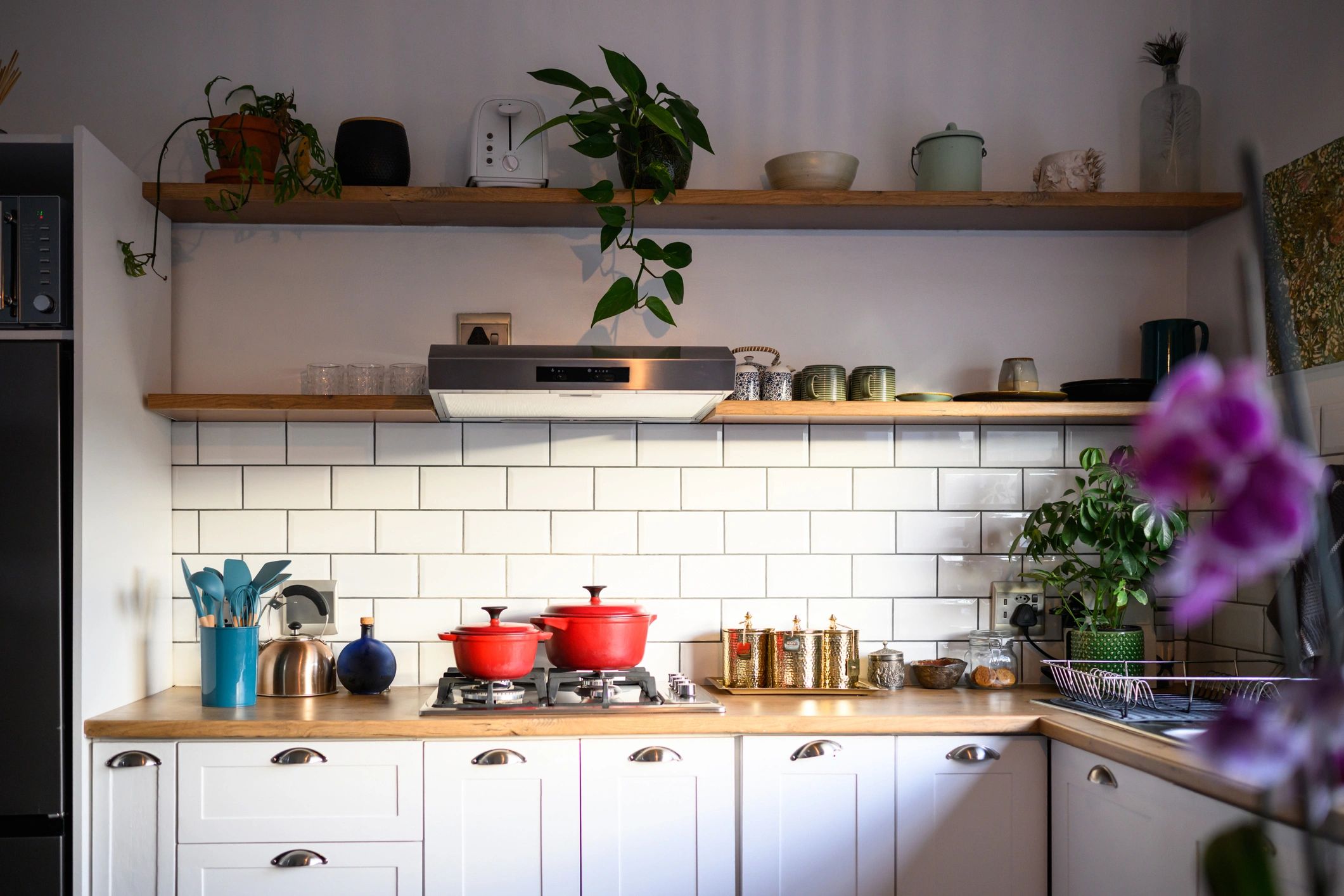 Bright modern kitchen with white cabinetry and subway tile splashback